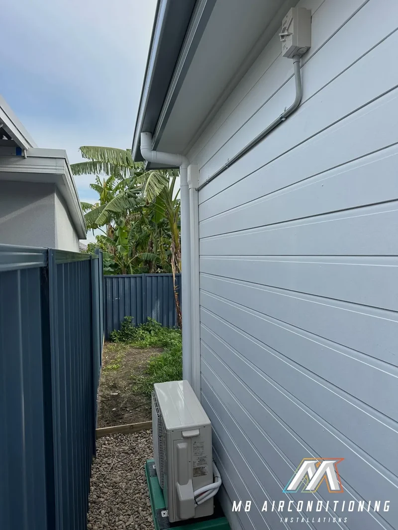 Outdoor air conditioning unit mounted on a weatherboard wall