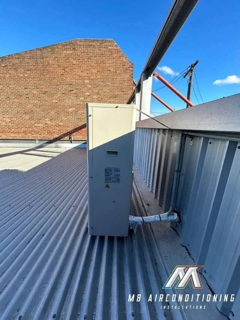 Commercial air conditioning unit installed on a shop rooftop between buildings