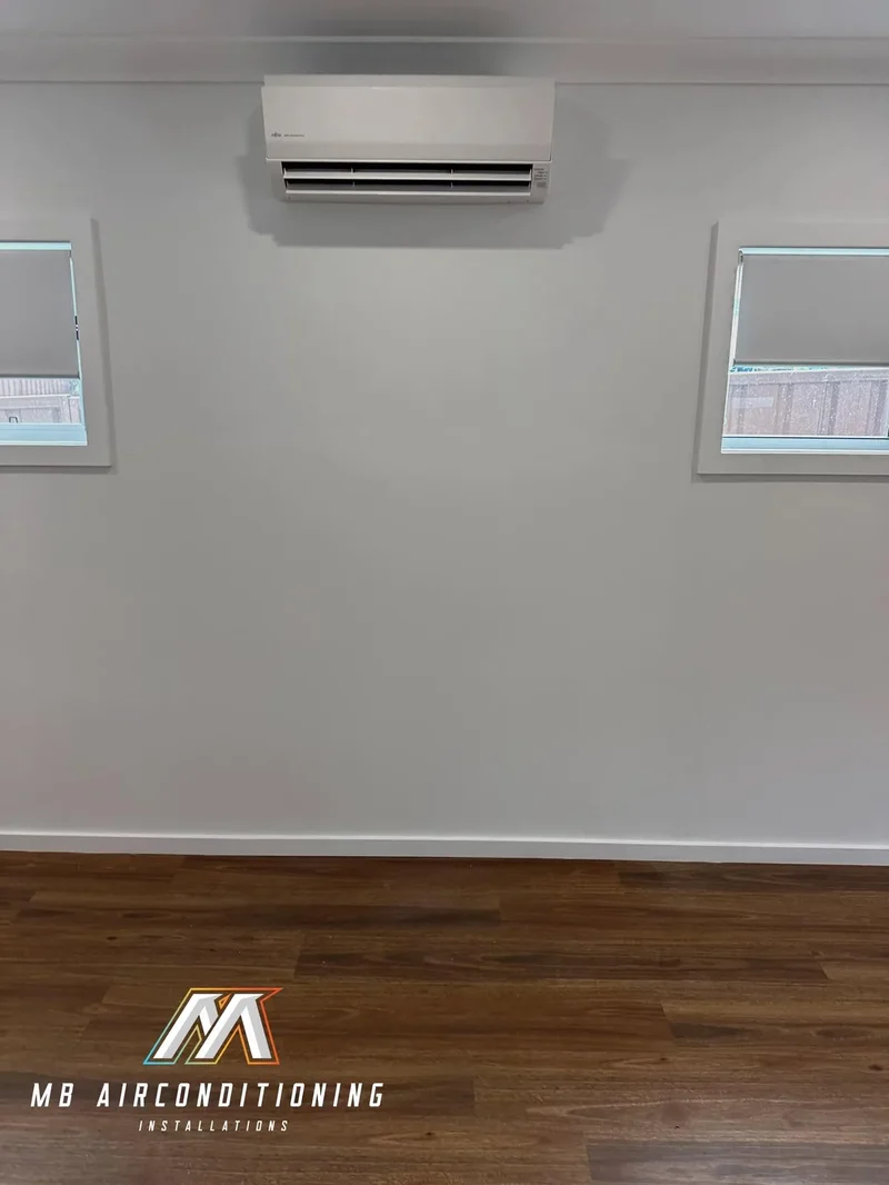 Split system head installed high on a bedroom wall with a clean pipe chase