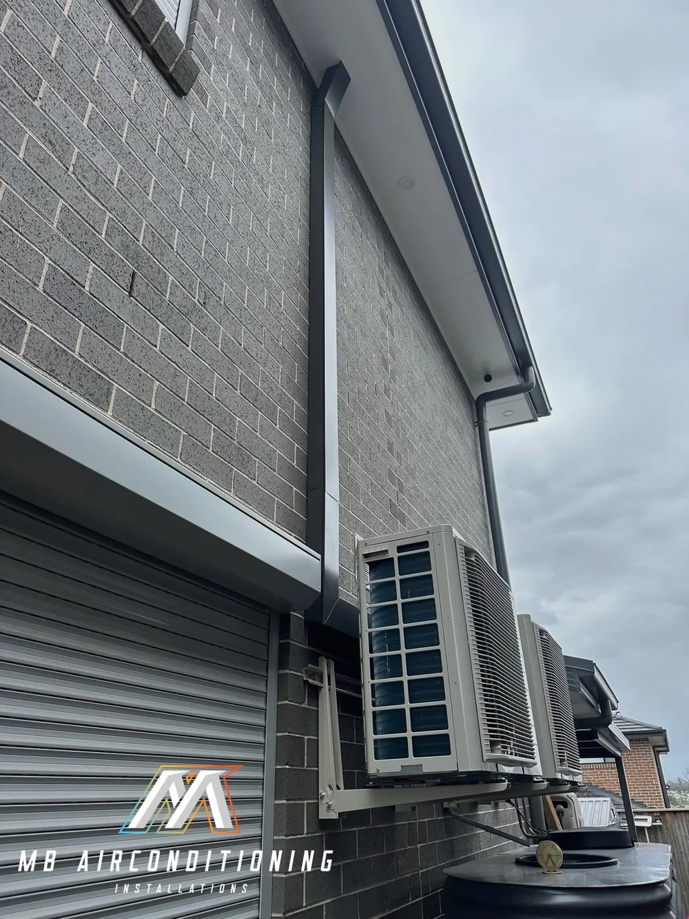 Outdoor air conditioning condenser being serviced beside a Sydney home